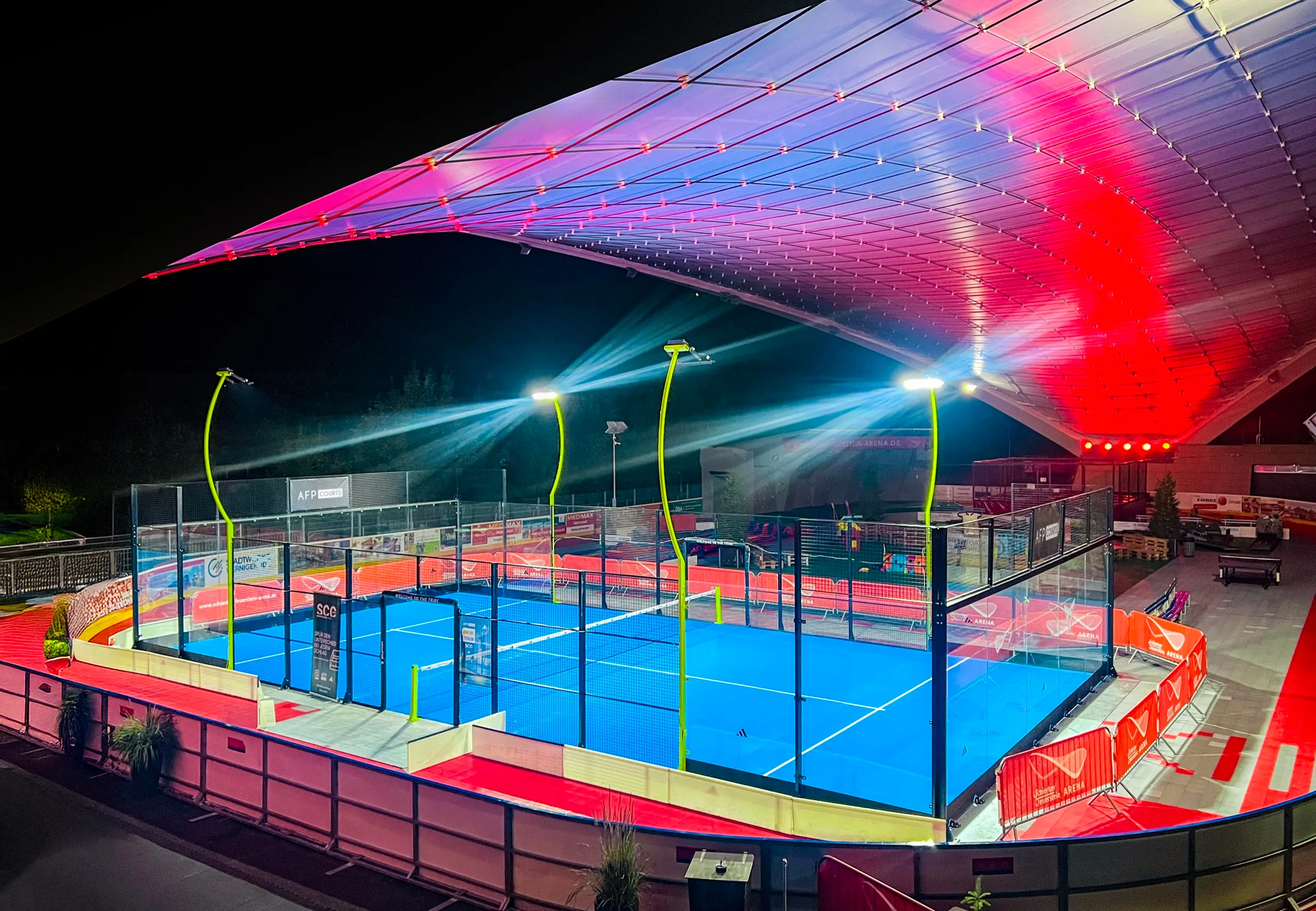 Pop-Up Court adidas PANOARENA 180° mit blauem Turf und gelben Lichtmasten bei Nacht